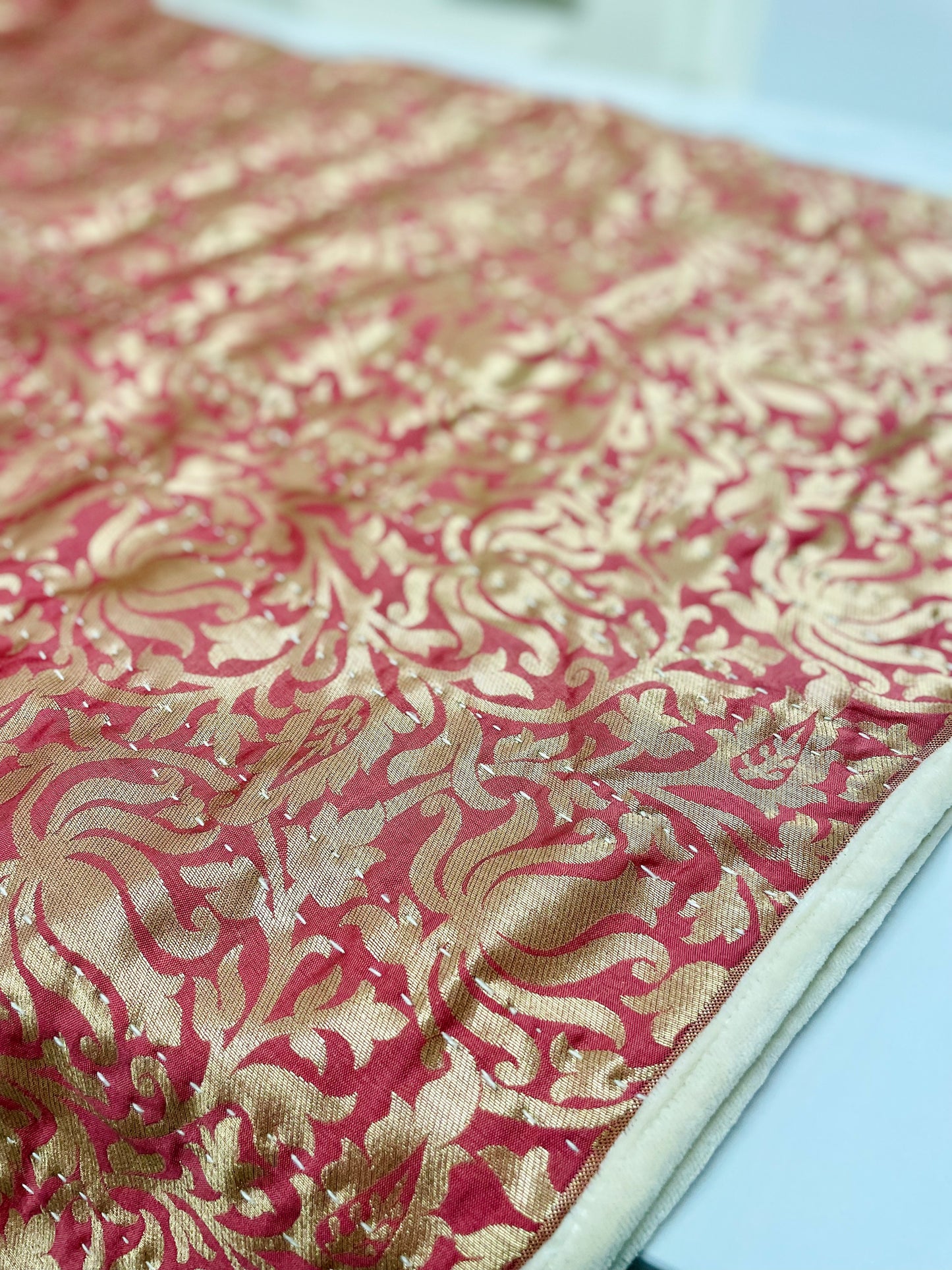 Close-up of red and gold patterned fabric.