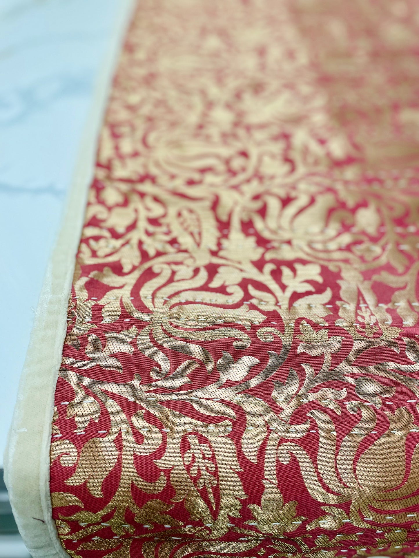 Close-up of red and gold patterned fabric.