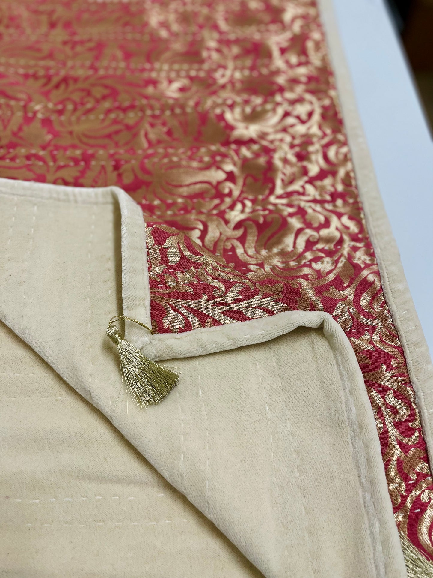 Textile with red and gold pattern and beige border